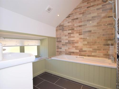 a bathroom with a bath tub and a sink at 3 Bed in Winkleigh 66043 in Winkleigh