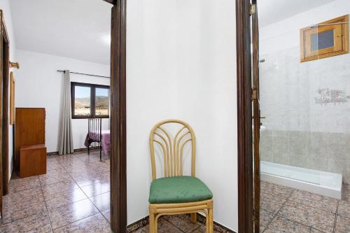 une chaise dans une pièce avec un miroir dans l'établissement Casa la solapa, à Pájara