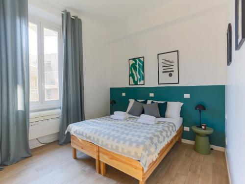 um quarto com uma cama grande e uma cabeceira azul em The Best Rent - Spacious two bedrooms apartment in Porta Romana em Milão