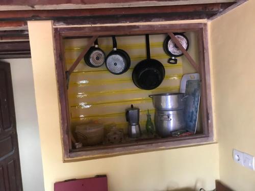 a shelf with pots and pans on a wall at studio bab guissa in Fès al Bali