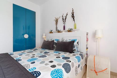 Schlafzimmer mit einem Bett in Blau und Weiß in der Unterkunft Bungalow Aloe Dunas 2 in Maspalomas
