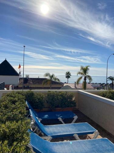 two lounge chairs and a swimming pool on a roof at Apartamentos HC Burriana Playa in Nerja