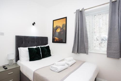 een witte slaapkamer met 2 bedden en een raam bij Westminster Suites by Sorted Stay in Southend-on-Sea