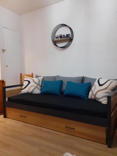 - un canapé avec des oreillers bleus et un miroir mural dans l'établissement Appartement au pied des pistes - Parking gratuit, à Les Deux Alpes