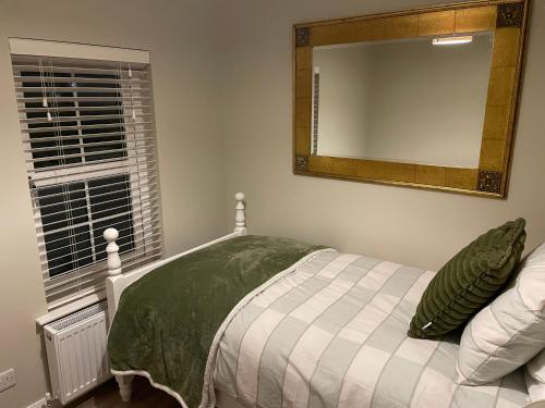 a bedroom with a bed with a mirror on the wall at The White House in Newry