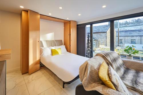 a bedroom with a bed and a large window at Host & Stay - Pâl Lodge in Holmfirth