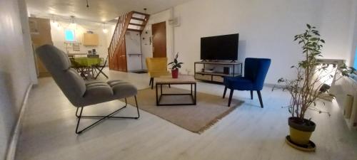 a living room with two chairs and a television at PATTON II in Pont-à-Mousson