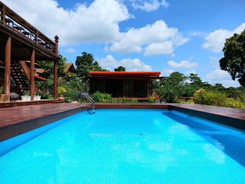 a swimming pool in front of a house at Baan mansin บ้านม่านศิลป์ in Pak Chong