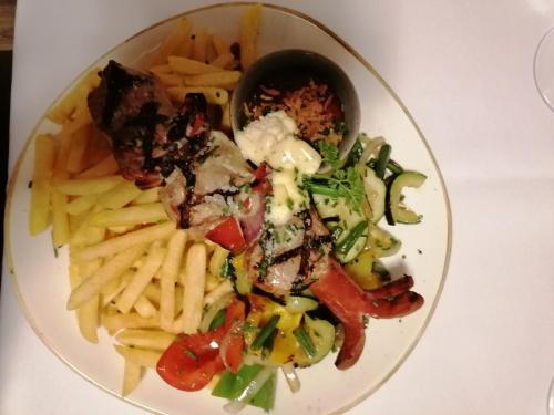 a plate of food with fries and meat and vegetables at Appartement Alpenglück in Aich