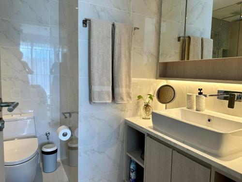 a bathroom with a sink and a toilet and a mirror at 2 bedroom Condo at Cassia Laguna in Bang Tao Beach