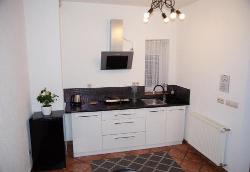 a white kitchen with a sink and a microwave at Noclegi "Poza Szlakiem" in Wałbrzych