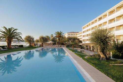 a large swimming pool in front of a hotel at Elea Beach Hotel in Dassia