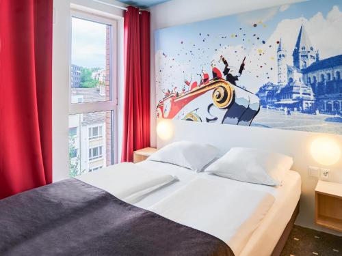 a bedroom with a bed and a large window at B&B Hotel Mainz-Hbf in Mainz