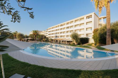 a swimming pool in front of a hotel at Elea Beach Hotel in Dassia