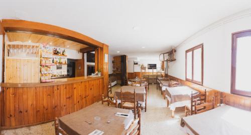 a dining room with tables and chairs and a bar at Coll de Port in Tuixen