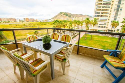 d'une table et de chaises sur un balcon avec vue. dans l'établissement ESPACIO 3 - Primera Línea de Playa, à Cullera