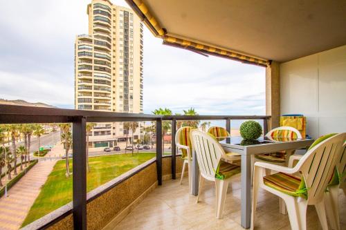 d'un balcon avec une table et des chaises offrant une vue sur la ville. dans l'établissement ESPACIO 3 - Primera Línea de Playa, à Cullera