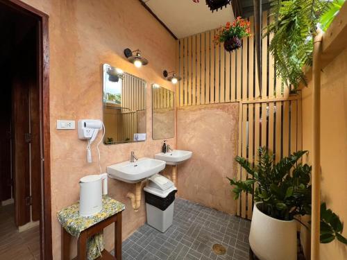 Baño con 2 lavabos y espejo en Sierra Hostel, en Nai Yang Beach