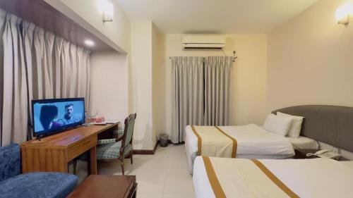 una camera d'albergo con due letti e una televisione di Hotel Fountain Luxury In Comfort a Dhaka