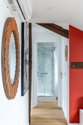 un couloir avec un miroir et un mur rouge dans l'établissement Appartement proche Paris 13ème arrondissement, à Ivry-sur-Seine