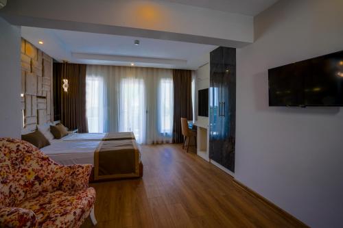 a hotel room with a bed and a couch at Lara Garden Hotel in Lara
