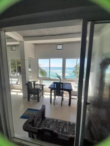a living room with a table and a view of the ocean at SEASHORE Resort & Villa in Talpe