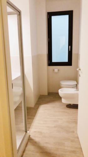 a bathroom with a toilet and a window at Resort Le Maree Cannigione in Cannigione