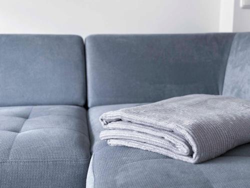 a pile of towels sitting on a couch at WELCOME 73m2 Ferienwohnung 10 Min. zum Bodensee in Bregenz