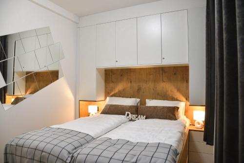 a bedroom with a bed with white cabinets at Sky Lux Apartments in Jahorina