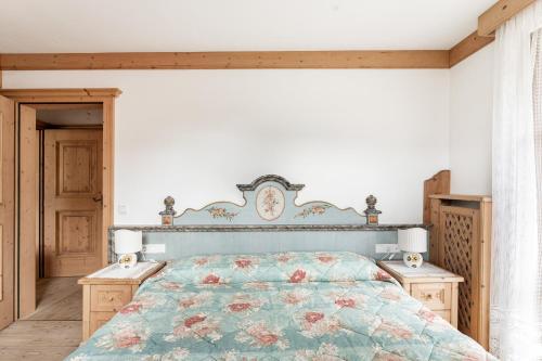 a bedroom with a bed and two night stands at Aurturist Appartement 185 in San Vigilio Di Marebbe