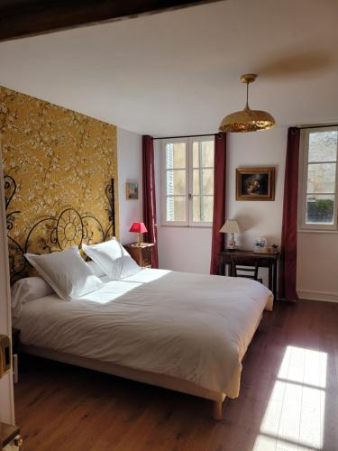 a bedroom with a large bed with white pillows at La Cour du Château in La Charité-sur-Loire