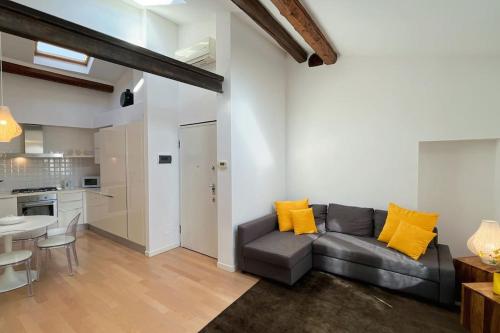 een woonkamer met een grijze bank en een keuken bij Casa Moira - Affitti Brevi Italia in Lecco