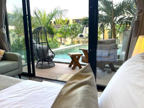 a bedroom with a view of a pool and a chair at Villa Bali Jeddah in Jeddah