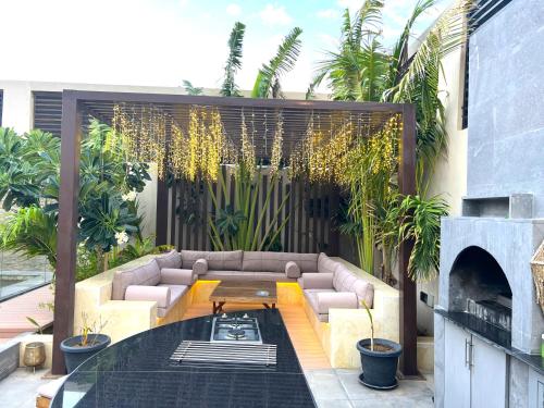 a patio with a couch and a table and plants at Villa Bali Jeddah in Jeddah