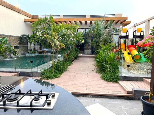 an outdoor patio with a pool and a playground at Villa Bali Jeddah in Jeddah