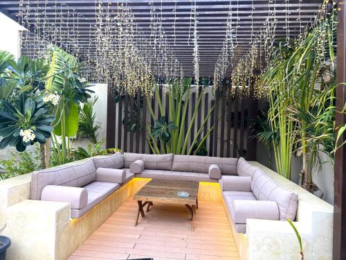 a patio with a couch and a table and plants at Villa Bali Jeddah in Jeddah