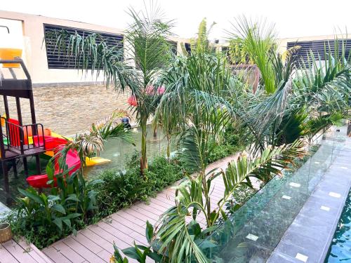 a garden with palm trees and a swimming pool at Villa Bali Jeddah in Jeddah