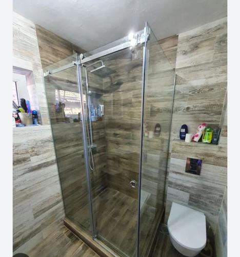 La salle de bains est pourvue d'une douche en verre et de toilettes. dans l'établissement AK STAN NA DAN, 