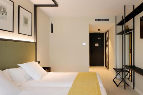 a bedroom with a white bed and a staircase at Nuvō Hotel Boutique in Oviedo
