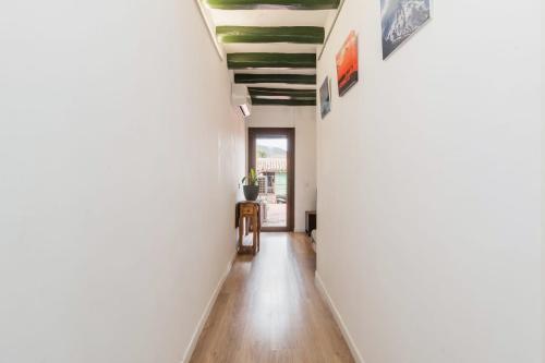 a hallway of a house with white walls and wooden floors at Apartament Montserrat in Piera
