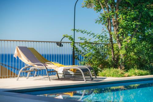 a pool with a chair next to a swimming pool at Casa da Cal - by Casas na Ilha in Câmara de Lobos