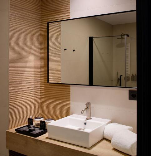 a bathroom with a white sink and a mirror at Nuvō Hotel Boutique in Oviedo