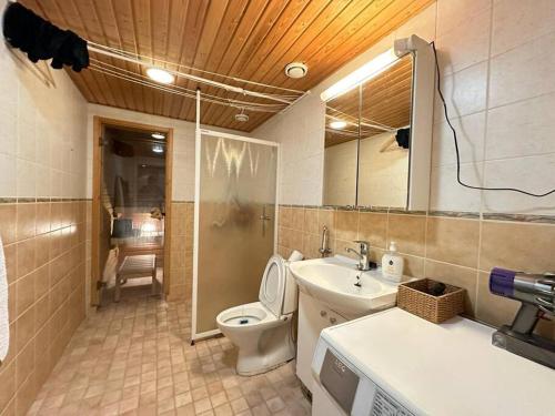 a bathroom with a toilet and a sink and a mirror at Moderni huoneisto saunalla! Keskustan lähellä, Merenrannassa, loistava varustelu! in Helsinki