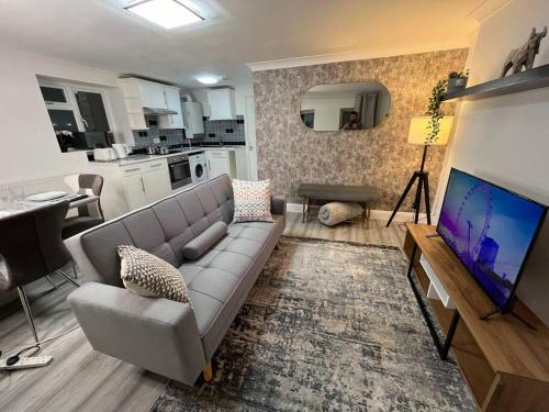 sala de estar con sofá y TV de pantalla plana en Modern & Stylish Haven In Heart of London, en Londres
