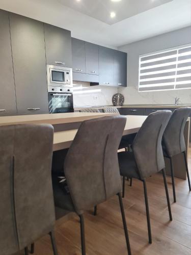 - une cuisine avec une table, des chaises et un four micro-ondes dans l'établissement Cocktail Apartment, à San Pawl il-Baħar