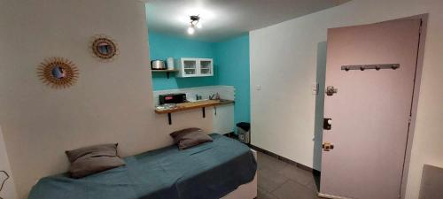 une chambre avec un lit et un mur bleu dans l'établissement Charmant studio, à Avignon