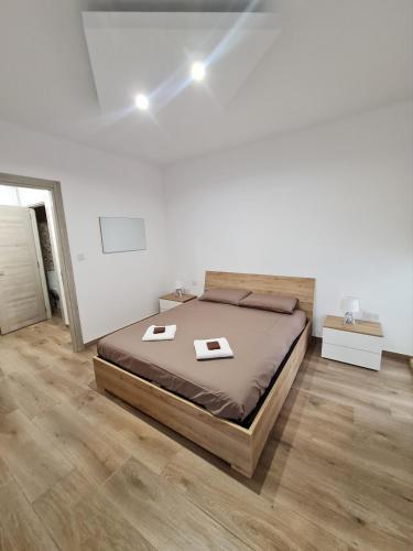 - une chambre blanche avec un lit dans l'établissement Cocktail Apartment, à San Pawl il-Baħar
