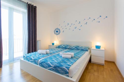 ein Schlafzimmer mit einem Bett mit blauer Bettwäsche und Vögeln an der Wand in der Unterkunft Activity villa Marula with outdoor pool in Buje in Gamboci