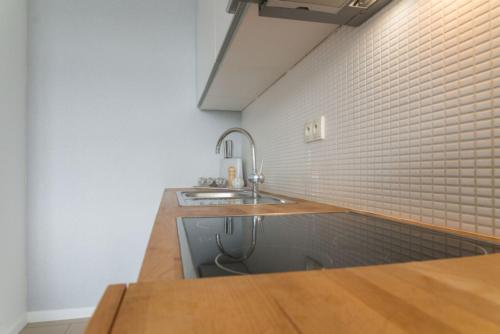 a kitchen with a sink and a brick wall at VacationClub – Bukowa 17 Apartament B.2 in Wisła