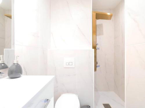 a white bathroom with a toilet and a shower at Escapade Vieux-Port balnéo ciné-terrasse by Weekome in Marseille